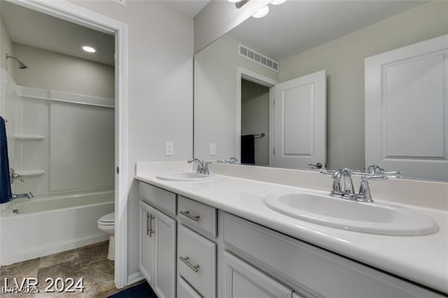 bathroom featuring double vanity, visible vents, toilet, and a sink