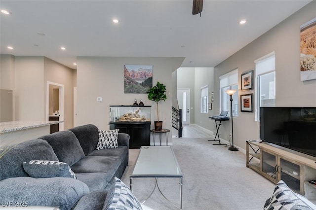 living area featuring light colored carpet, recessed lighting, baseboards, and a ceiling fan