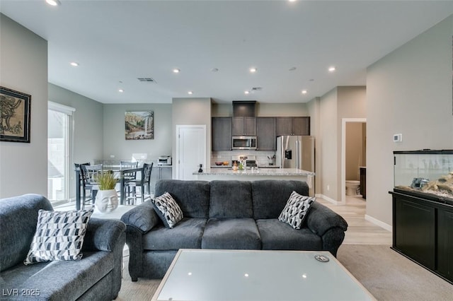 living area with recessed lighting, baseboards, and visible vents