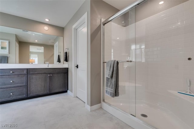 bathroom featuring vanity, baseboards, a shower stall, and tile patterned floors