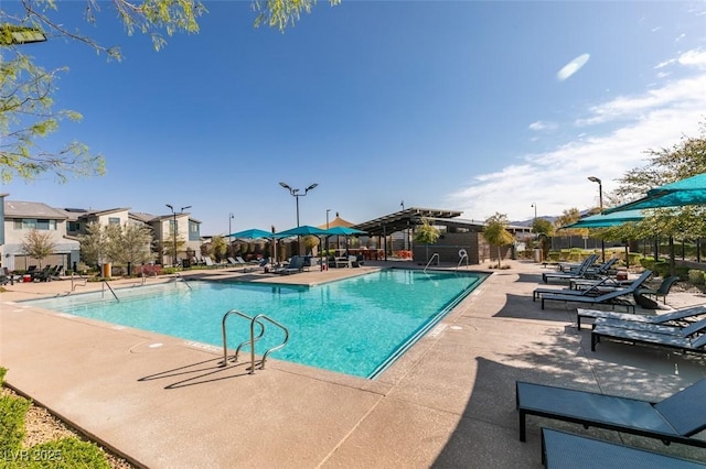 community pool featuring fence and a patio area