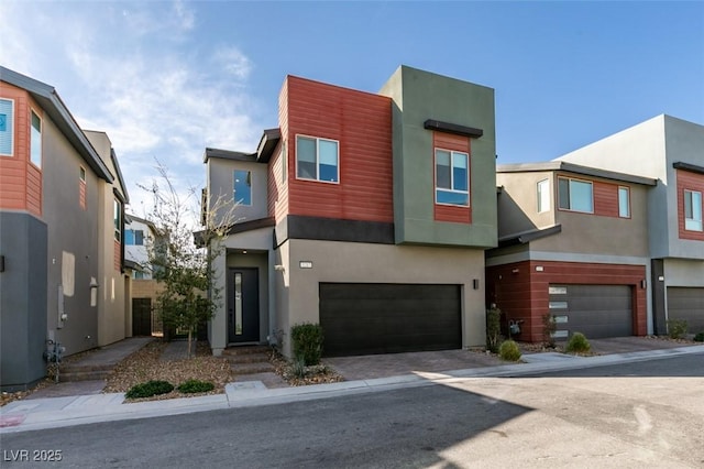 modern home featuring an attached garage, stucco siding, and driveway