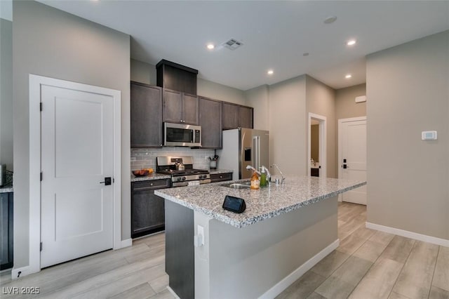 kitchen featuring a sink, stainless steel appliances, light wood-style flooring, and visible vents