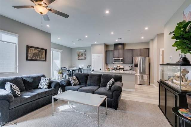 living room featuring recessed lighting, a ceiling fan, and light wood-type flooring