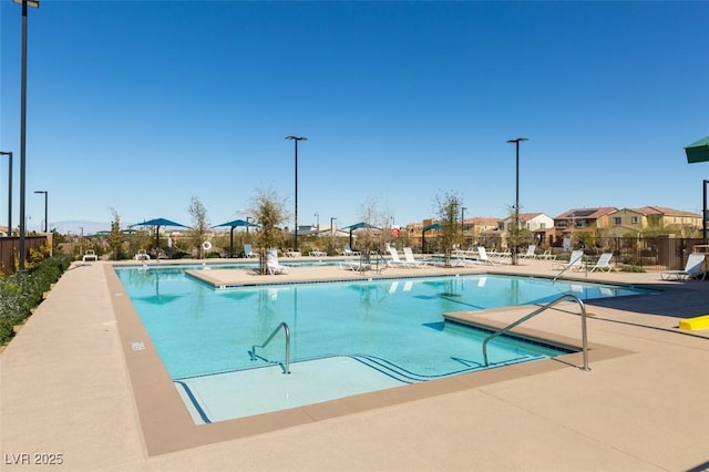 community pool featuring a patio and fence