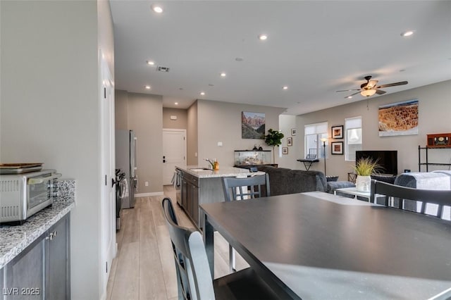 dining room with recessed lighting, light wood-style floors, and a toaster