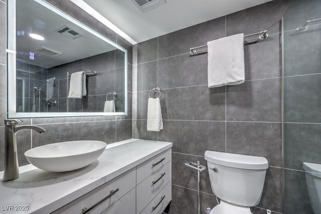 bathroom with visible vents and tile walls