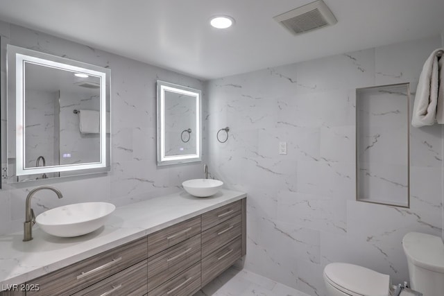 full bath featuring marble finish floor, visible vents, toilet, and a sink