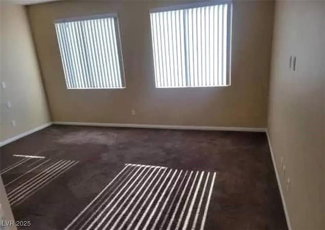 spare room featuring baseboards and carpet floors