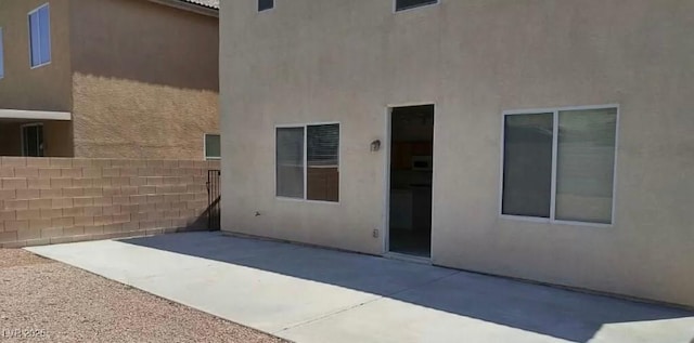 3883 Winter Whitetail St, Las Vegas, NV 89122 - rear view of property with stucco siding, fence, and a patio