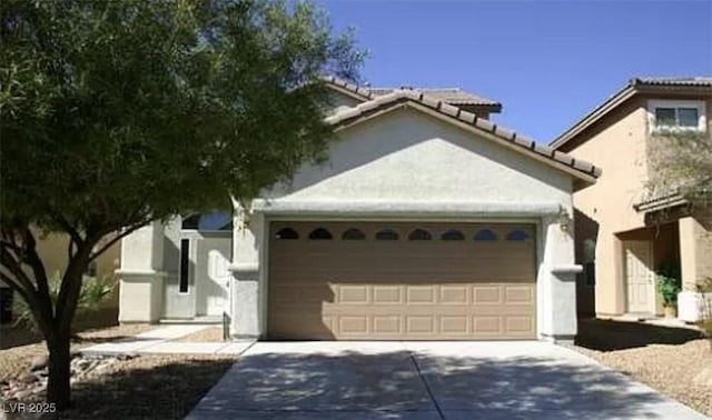 3883 Winter Whitetail St, Las Vegas, NV 89122 - view of front facade featuring a tiled roof, driveway, stucco siding, and an attached garage