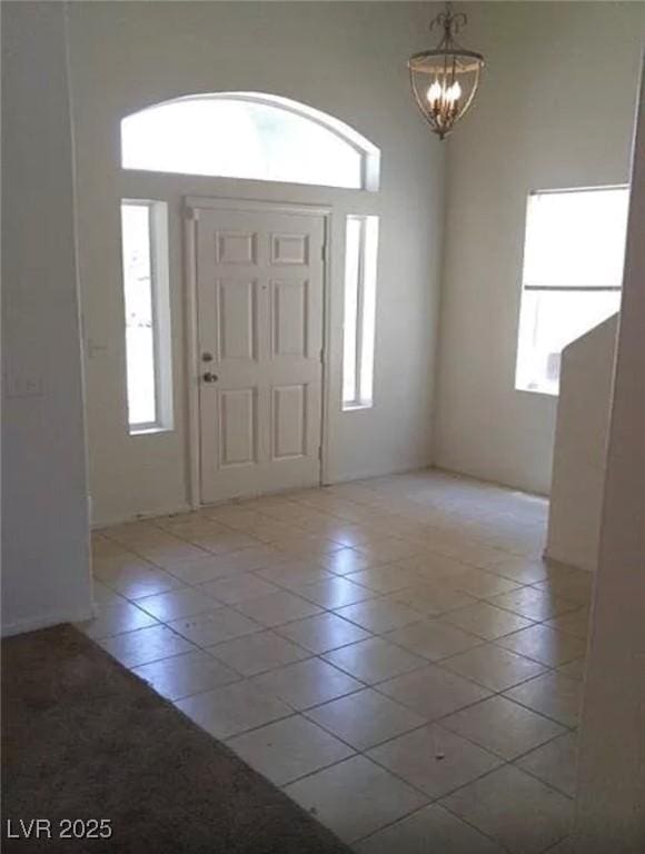 3883 Winter Whitetail St, Las Vegas, NV 89122 - foyer entrance with light tile patterned floors, plenty of natural light, and a chandelier