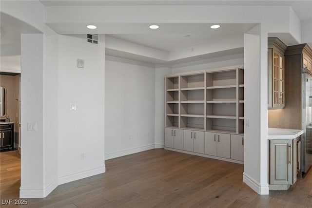 interior space with wood finished floors, visible vents, and baseboards