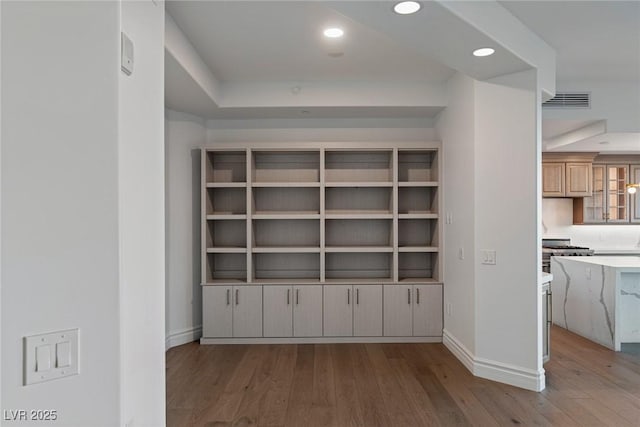 interior space featuring visible vents, baseboards, wood finished floors, and recessed lighting
