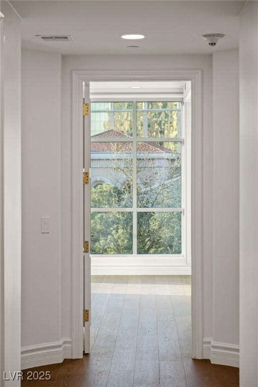 doorway to outside with hardwood / wood-style floors, baseboards, and visible vents