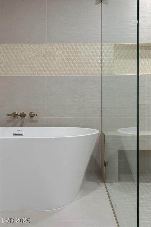 bathroom with a freestanding bath, tile patterned flooring, and a stall shower