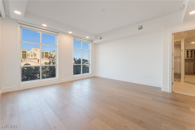 unfurnished room with visible vents, light wood-style flooring, baseboards, and recessed lighting