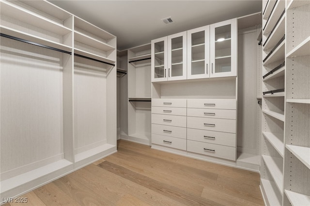 spacious closet with light wood-style floors and visible vents