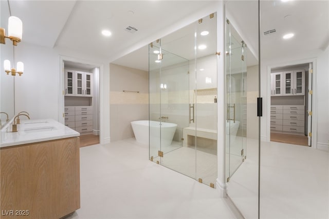 full bathroom with a sink, a stall shower, a soaking tub, double vanity, and visible vents