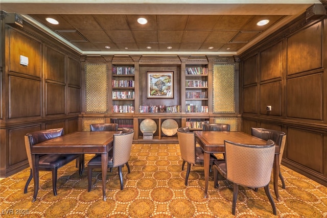 dining space with built in shelves, a decorative wall, ornamental molding, and recessed lighting