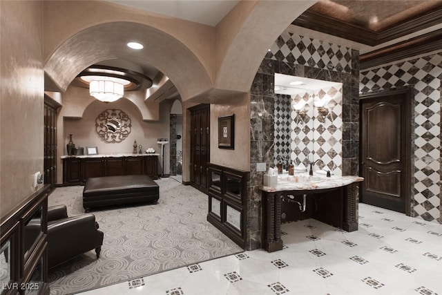 wine room featuring arched walkways and ornamental molding