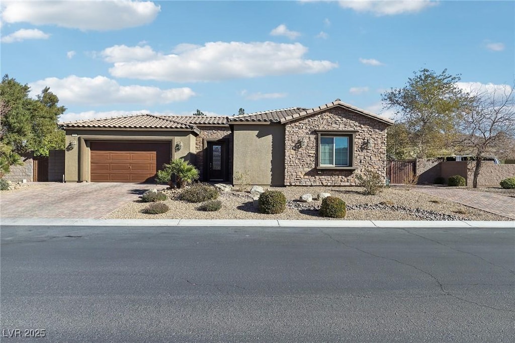8716 Purple Wisteria St, Las Vegas, NV 89131 - view of front of home with a tiled roof, stucco siding, fence, an attached garage, and driveway