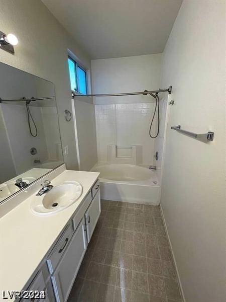 full bathroom featuring washtub / shower combination, baseboards, and vanity