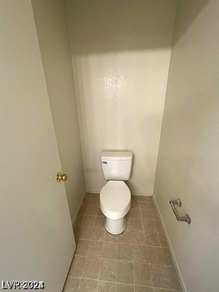 bathroom featuring toilet and baseboards