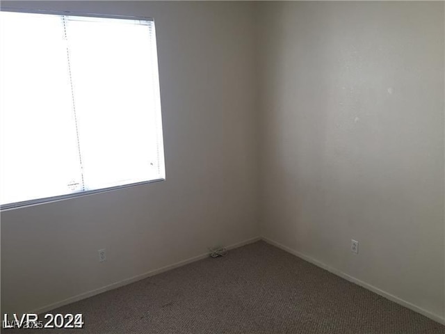 carpeted empty room with baseboards