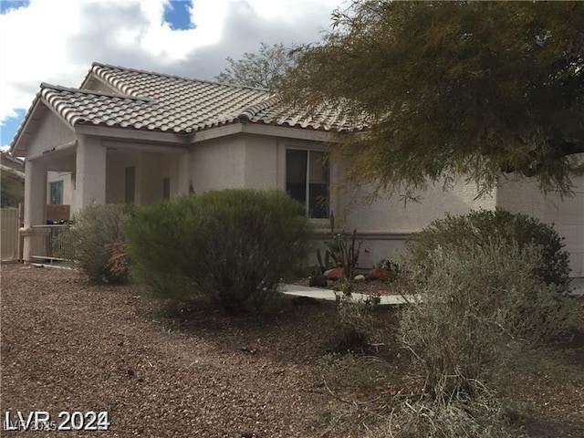 view of home's exterior featuring a tiled roof and stucco siding