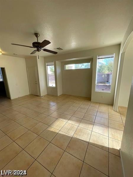 empty room featuring visible vents, ceiling fan, and light tile patterned floors