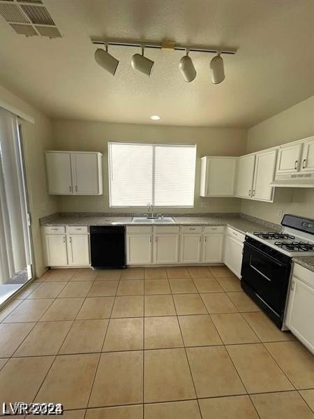 kitchen with light tile patterned flooring, a sink, dishwasher, under cabinet range hood, and range with gas cooktop