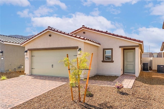 2618 Lily Point St, Las Vegas, NV 89156 - mediterranean / spanish-style home with decorative driveway, an attached garage, central AC, stucco siding, and a tile roof