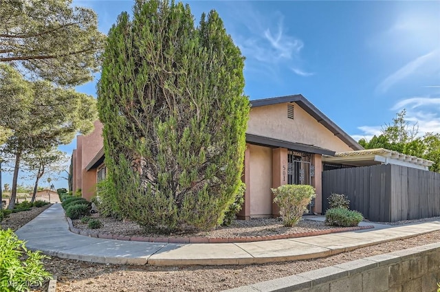 view of front of property with stucco siding and fence