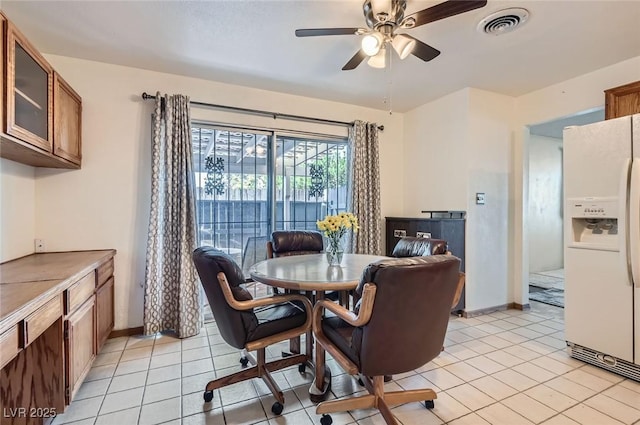 dining area with light tile patterned floors, visible vents, baseboards, and a ceiling fan