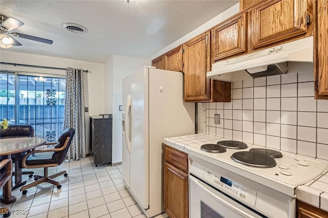 kitchen with visible vents, ceiling fan, under cabinet range hood, decorative backsplash, and tile countertops