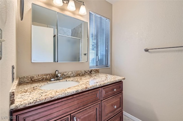 full bathroom featuring a stall shower and vanity