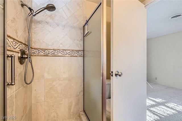 bathroom with visible vents, a stall shower, and toilet
