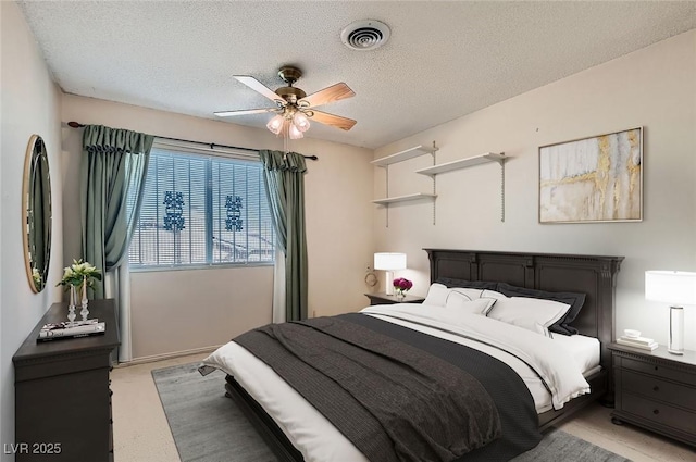 bedroom featuring visible vents, a ceiling fan, light carpet, and a textured ceiling