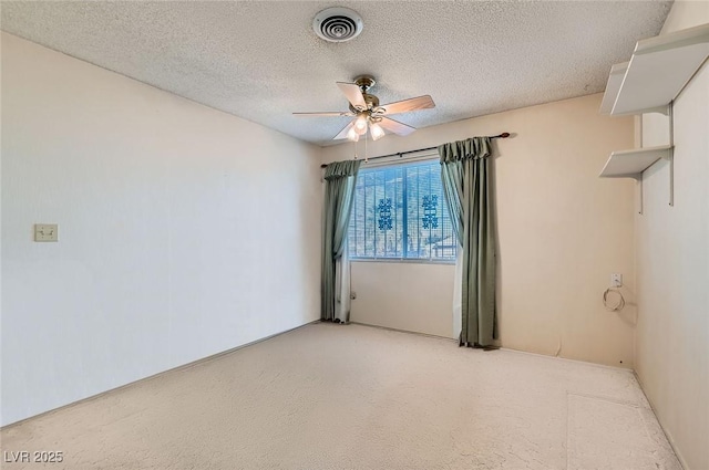 unfurnished room featuring a textured ceiling, a ceiling fan, and visible vents