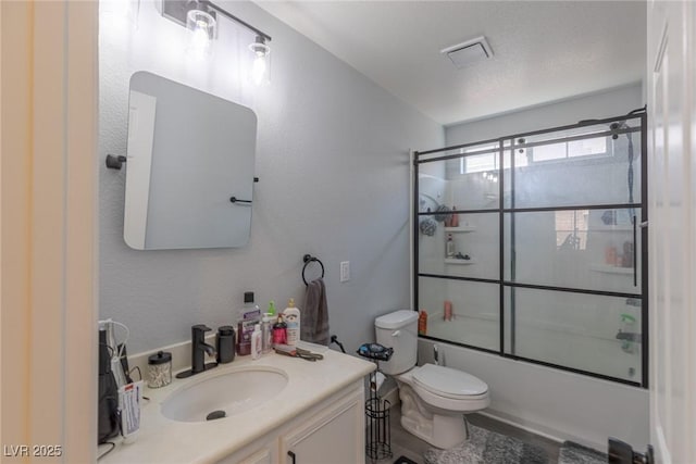 full bathroom featuring vanity, combined bath / shower with glass door, toilet, and visible vents