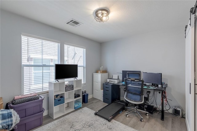 office space featuring light wood-type flooring and visible vents