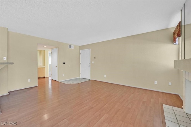7901 Idledale Ct Unit 102, Las Vegas, NV 89145 - unfurnished living room with light wood-type flooring, baseboards, and a tile fireplace