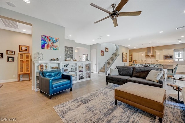 10840 Rosin Jaw St, Las Vegas, NV 89183 - living room with stairway, visible vents, a ceiling fan, and light wood-style flooring