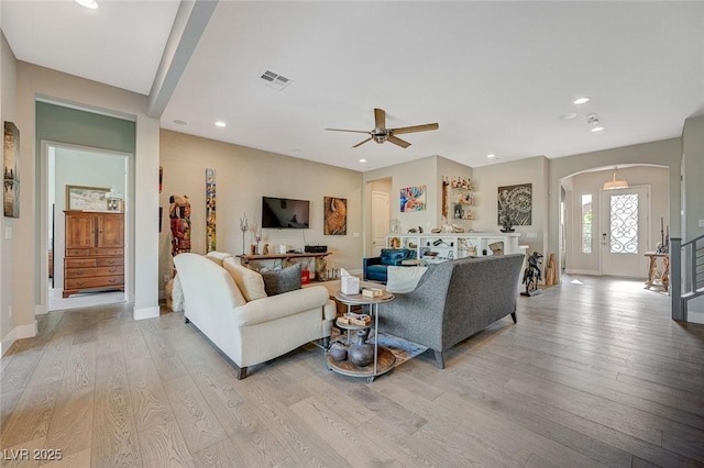 10840 Rosin Jaw St, Las Vegas, NV 89183 - living room with arched walkways, ceiling fan, visible vents, and light wood-style floors
