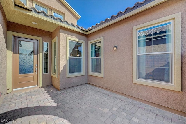 10840 Rosin Jaw St, Las Vegas, NV 89183 - doorway to property featuring a patio, stucco siding, and a tile roof