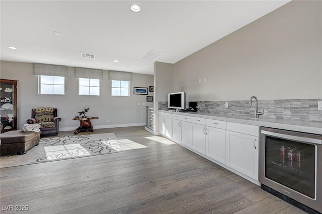 10840 Rosin Jaw St, Las Vegas, NV 89183 - interior space featuring visible vents, white cabinets, light countertops, wine cooler, and light wood finished floors