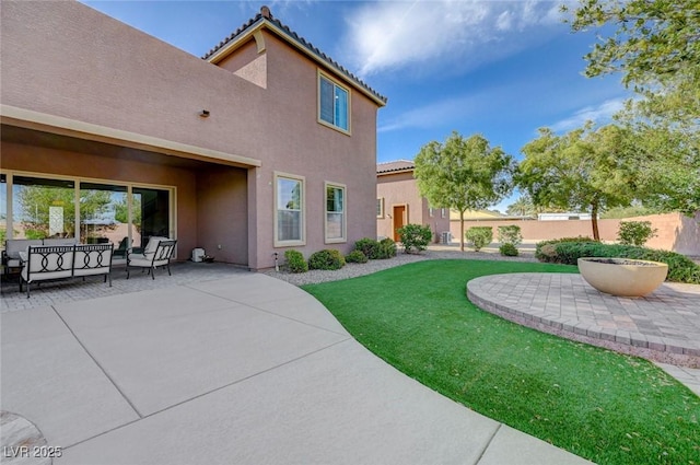 10840 Rosin Jaw St, Las Vegas, NV 89183 - back of house featuring a patio, stucco siding, a tiled roof, fence, and a lawn