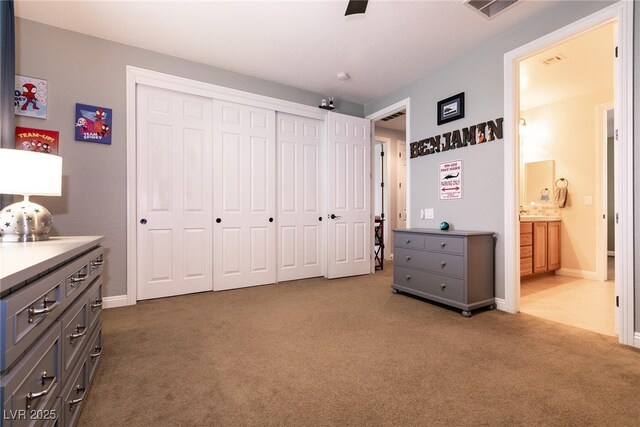7416 Redhead Dr, North Las Vegas, NV 89084 - bedroom with dark colored carpet, a closet, ensuite bathroom, baseboards, and a ceiling fan