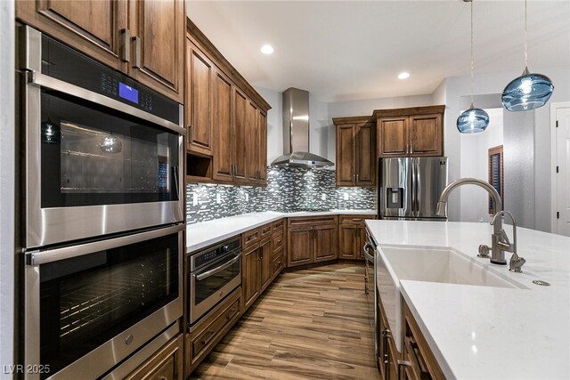 7416 Redhead Dr, North Las Vegas, NV 89084 - kitchen featuring appliances with stainless steel finishes, wall chimney range hood, light wood-type flooring, light countertops, and recessed lighting